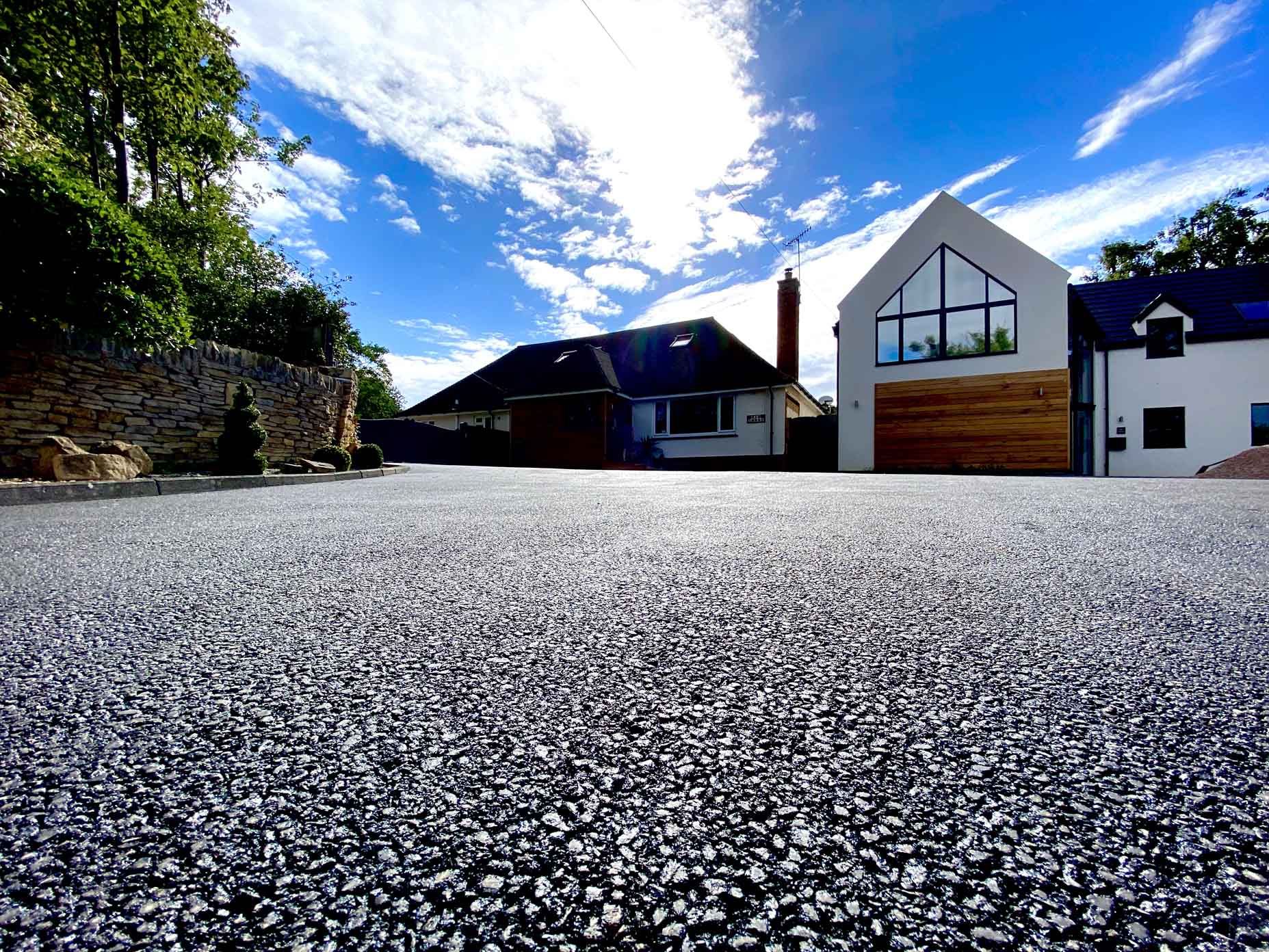 A Tarmac driveway in-front of a modern house