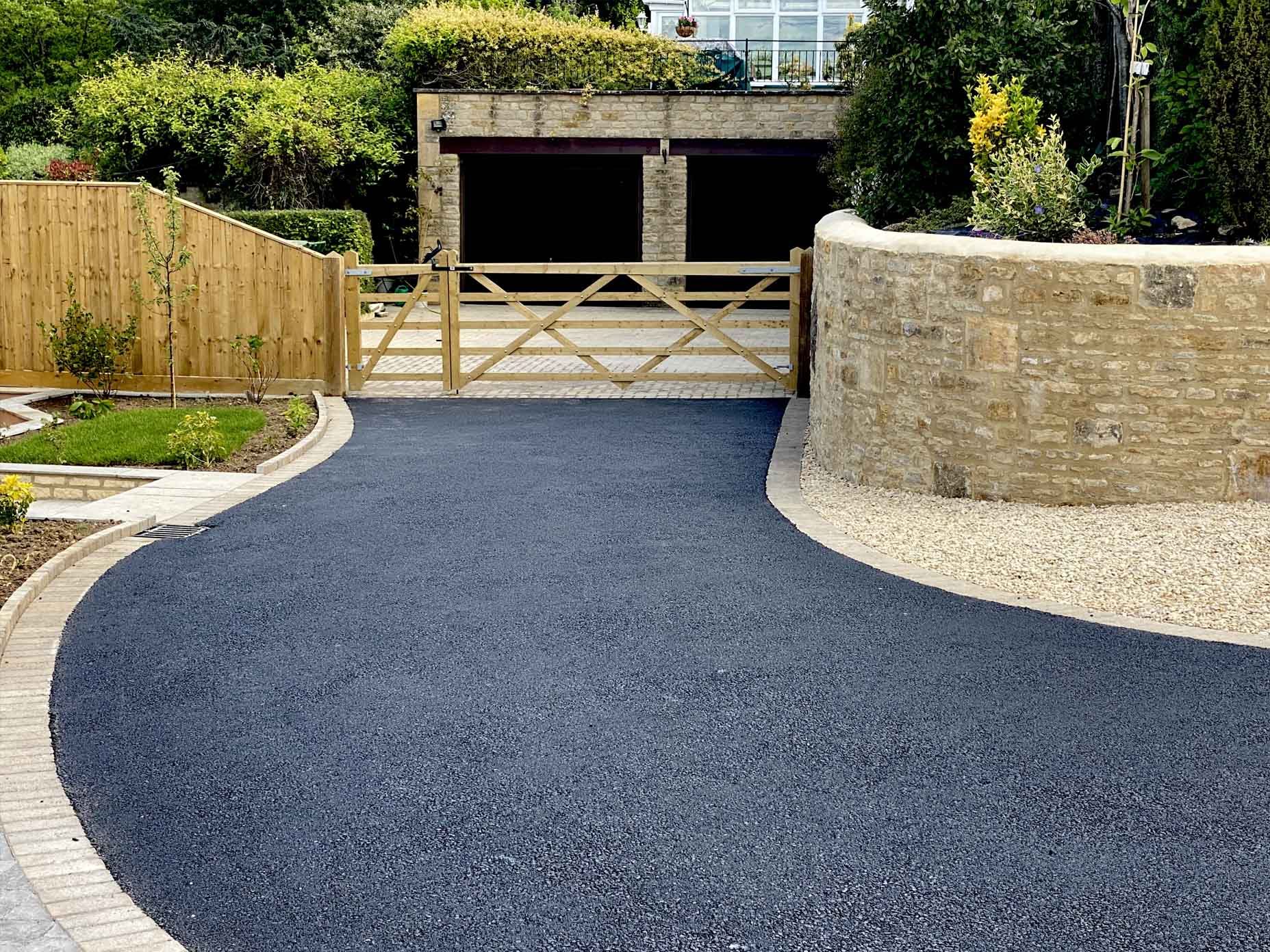 Tarmac driveway leading to a house gate, showcasing the smooth and durable surface of our tarmac driveways