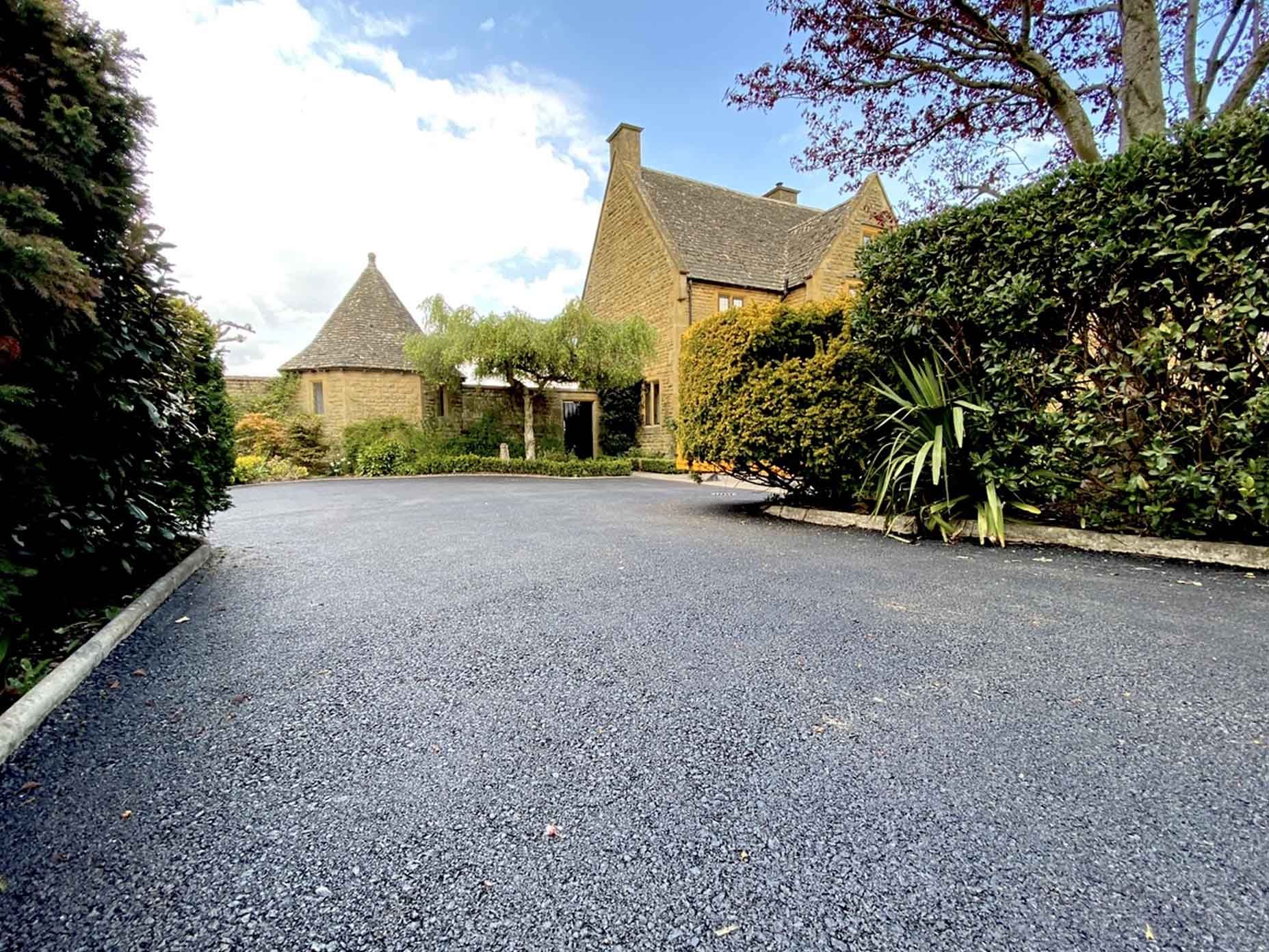 A Tarmac driveway in-front of a country house